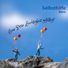 Kleine Figuren mit Ballons auf Steinen